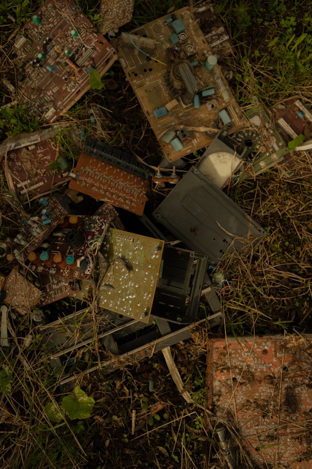 a pile of old broken electronics in the grass