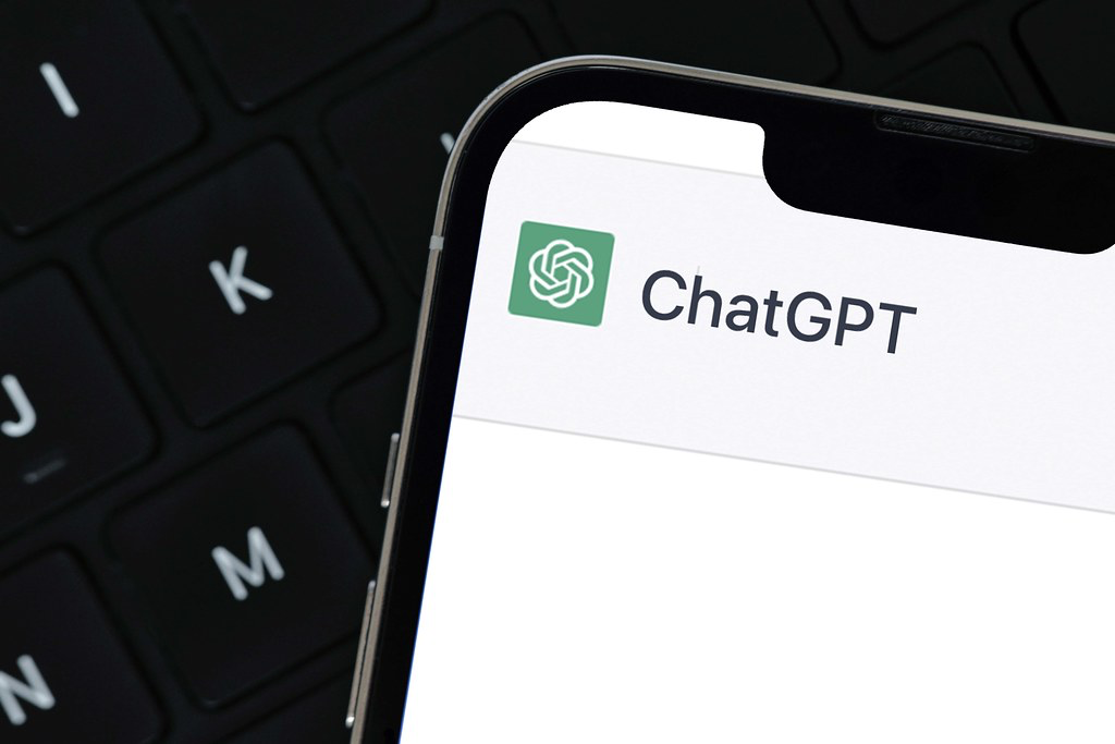 computer keyboard background with smart phone displaying ChatGPT App